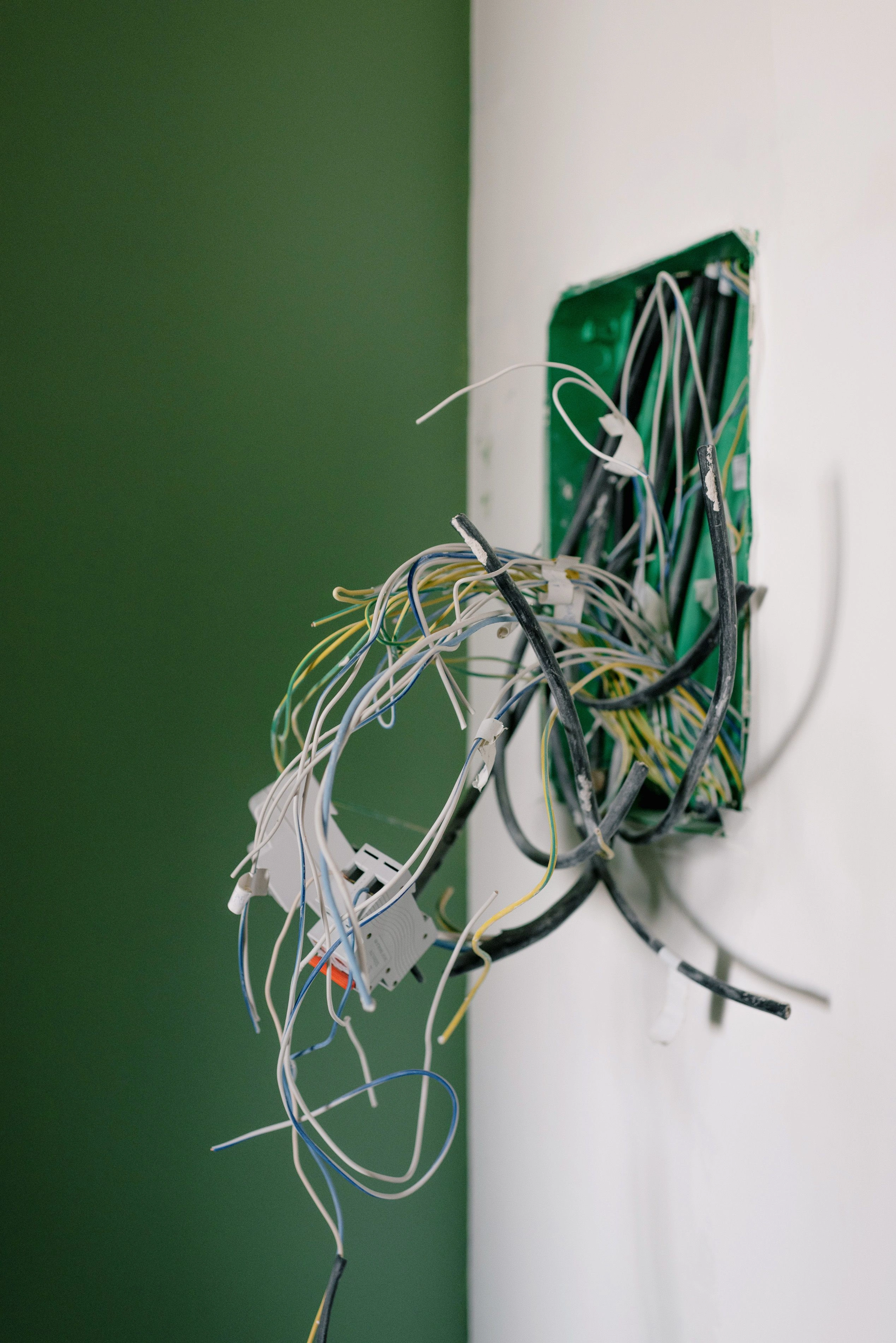 Staré elektrické káble trčiace zo steny pred rekonštrukciou